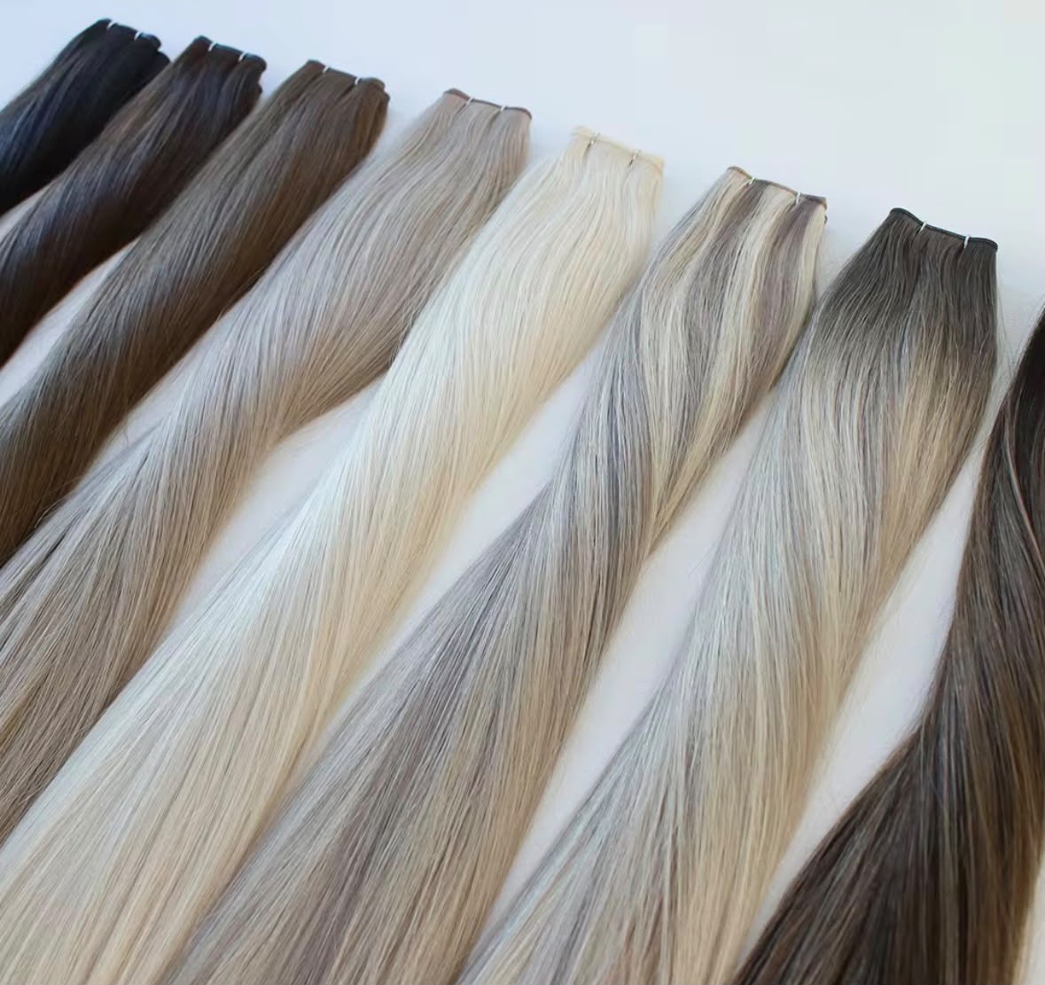 Row of straight hair wefts in natural dark, brown and blonde tones — Signature