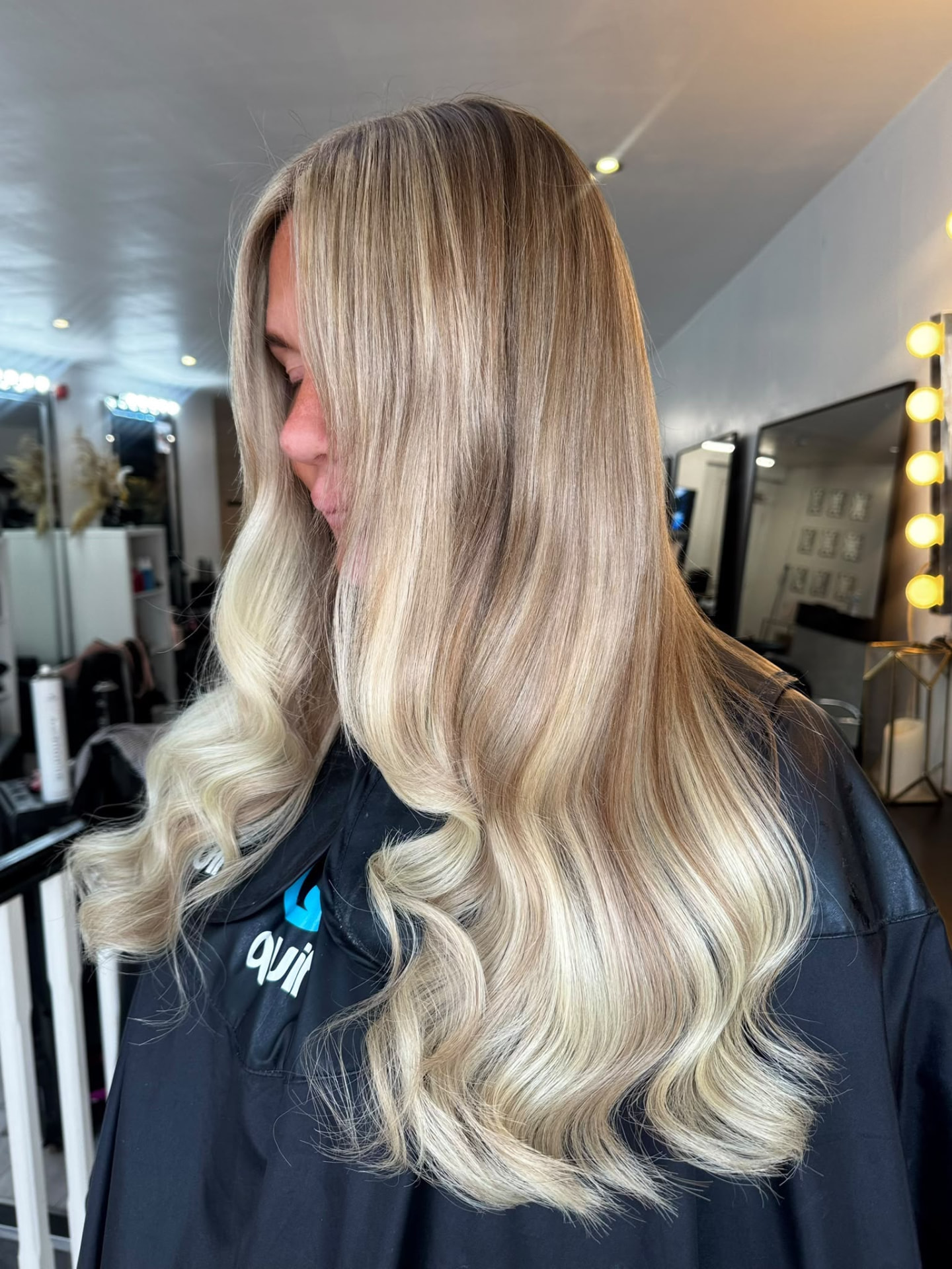 Creamy blonde hair extensions with blended roots and glossy waves